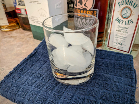 a rocks glass filled with white, crescent-shaped ice cubes