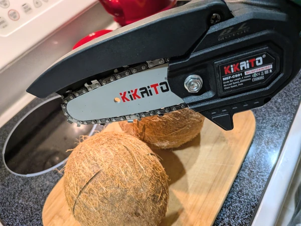 The two coconuts from a different angle, with their wrappers removed. A small chainsaw attachment hovers over them threateningly