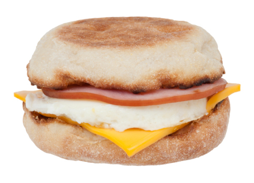 a photograph of an Egg McMuffin, made up of an English muffin, egg, cheese, and Canadian bacon