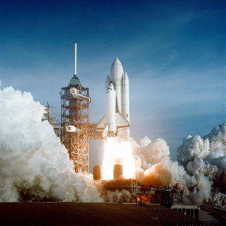 a space shuttle blasting off from its launchpad